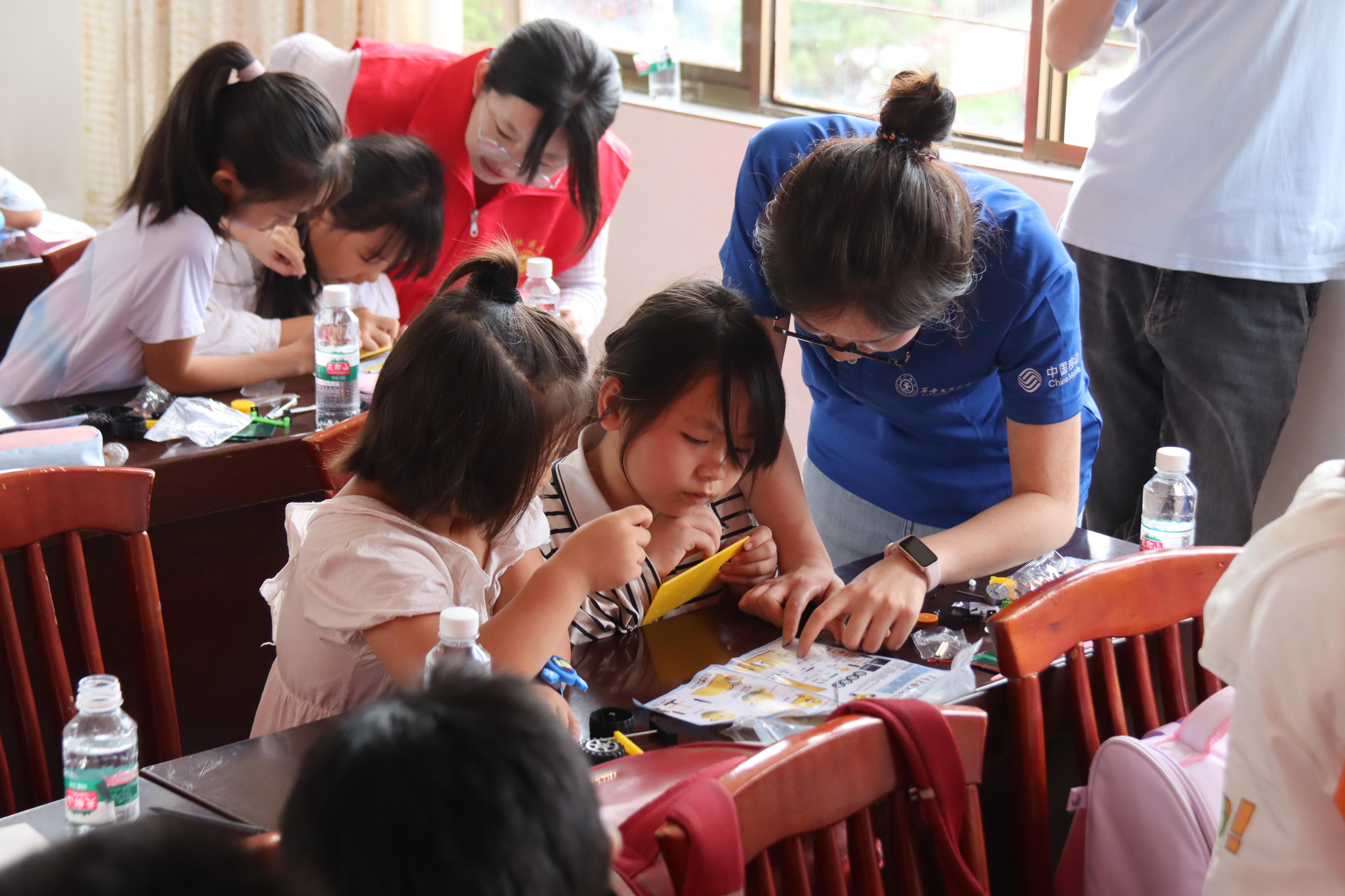 7-小学生在实践队员和志愿者指导下组装太阳能小车