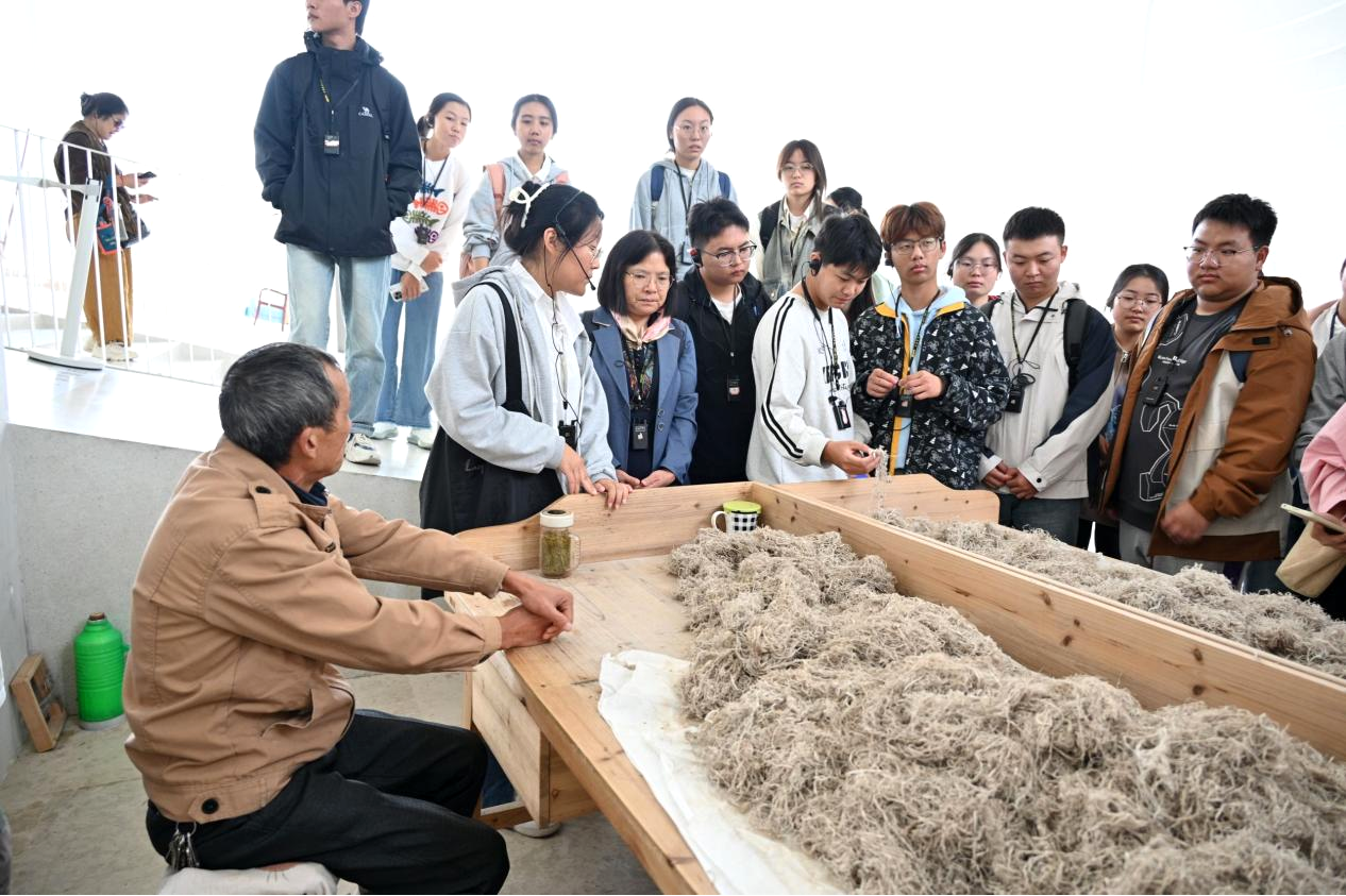 图8 汪盛玉与同学们一起体验宣纸原料